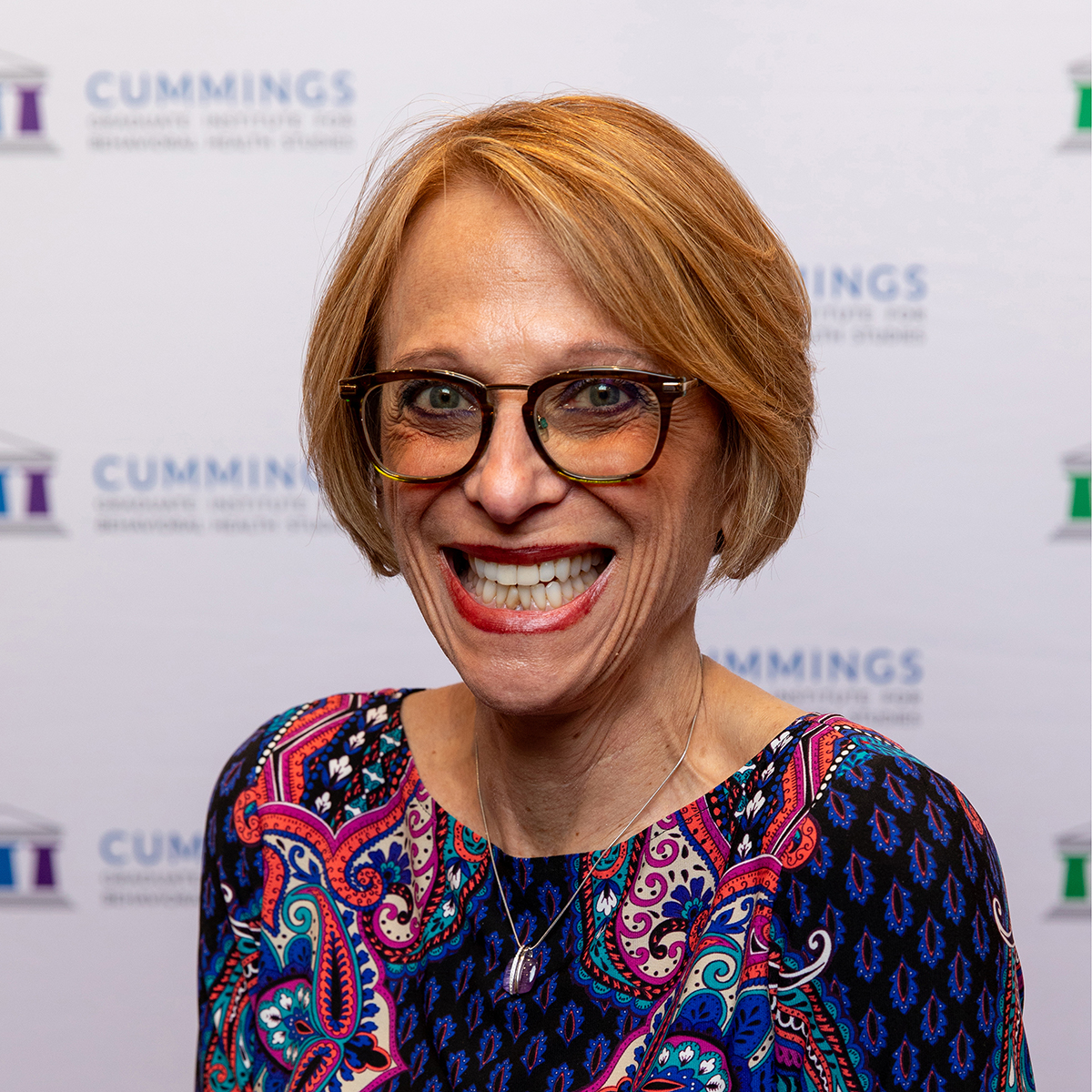 Dr. Ellen Fink-Samnick in front of a CGI background
