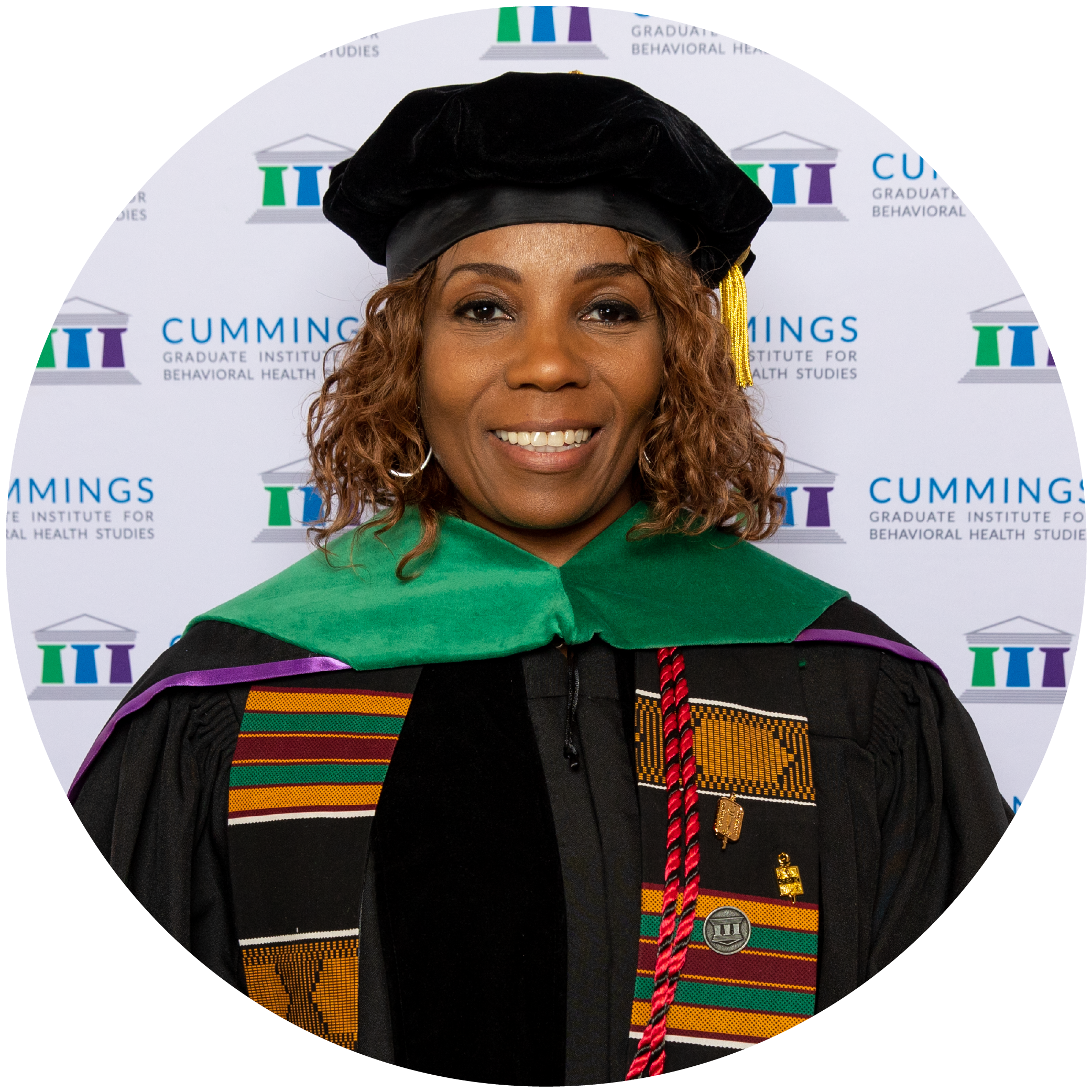Dr. Andreena M. Jackson, DBH, MSSA, LSW, wearing academic regalia and smiling in front of a Cummings Graduate Institute backdrop.