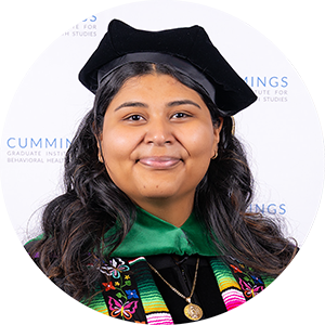 DBH graduate Dr. Destinee Rodriguez, DBH, BCBA smiling in academic regalia and doctoral tam.