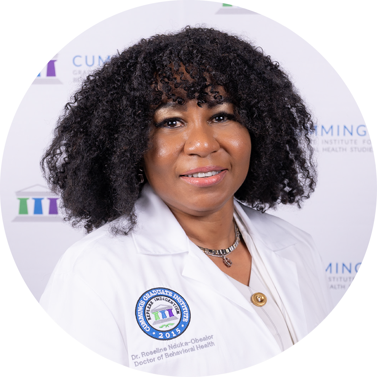 Dr. Roseline Obealor, DBH, wearing a CGI white coat at the DBH commencement ceremony.