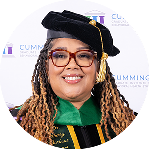 DBH graduate Dr. Sherry Barbour smiling in academic regalia and doctoral tam.