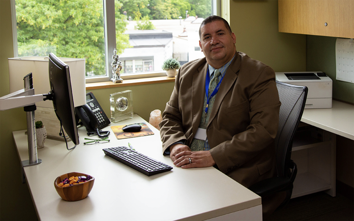 Doctor of Behavioral Health student Jose Morell, a bilingual licensed mental health counselor, seated in his counseling office.