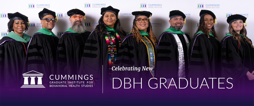 Eight Doctor of Behavioral Health graduates in academic regalia at CGI’s June 2026 DBH commencement ceremony.