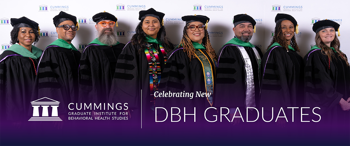 Eight Doctor of Behavioral Health graduates in academic regalia at CGI’s June 2026 DBH commencement ceremony.